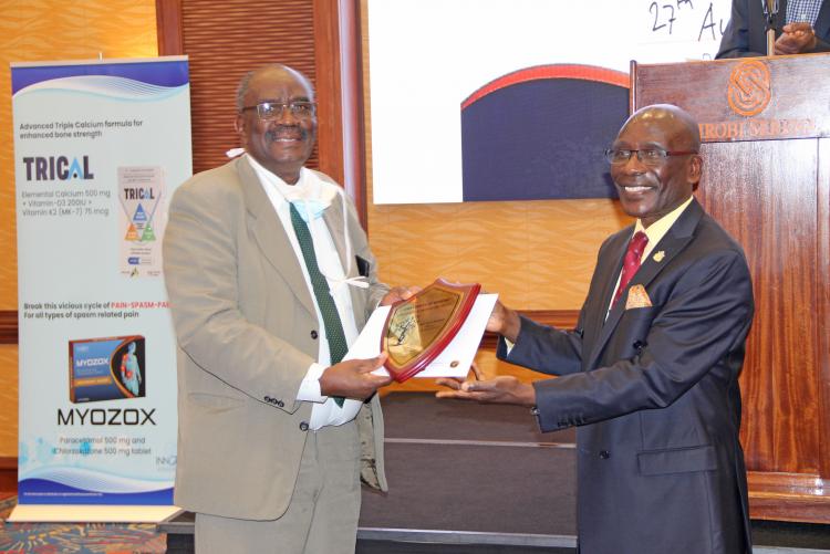 Prof. Josephat Mulimba (L) receives an award from Prof. Julius Ogeng'o during the farewell dinner.