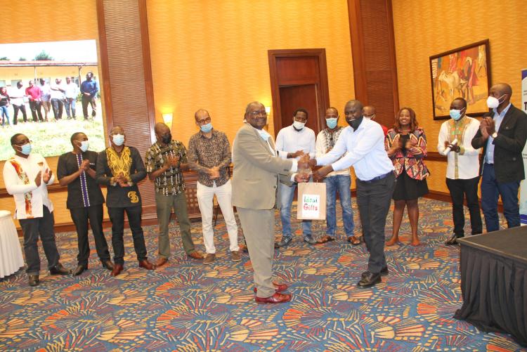 Prof. Josephat Mulimba receives a gift from the 2021 graduating class during his farewell dinner.