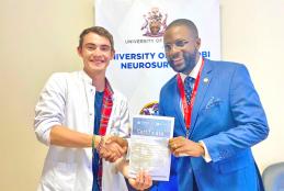 Marius Gûntert (L) receives a certificate from Dr. Michael Magoha (R).